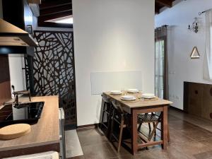 a kitchen with a wooden table in a room at Cadriano House in Granarolo dellʼEmilia