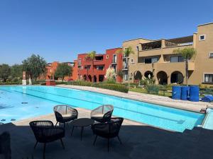a swimming pool with chairs and a table and some buildings at Condominio de Lujo en San Miguel in San Miguel de Allende