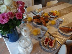 La CoudreにあるLa Tente du Chercheur d'Orの朝食用の食材、花、オレンジジュースを用意したテーブル