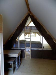La CoudreにあるLa Tente du Chercheur d'Orのテント内のベッドルーム(ベッド1台、ベンチ付)