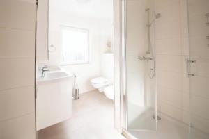 a bathroom with a toilet and a sink and a shower at Ferienhaus Ariane - Achterwasser-Findling in Netzelkow +18 photos