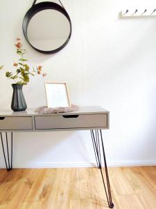 einen Schminktisch mit einem Spiegel an der Wand in der Unterkunft Flair-Apartments 'Apartment nähe Schlosspark', 300 m Bahnhof, Innenstadt Bad Salzuflen Stadtteil Schötmar, für Urlaub oder Geschäftsreise, separater Eingang, 24 Std Check-in,WLAN, Streaming-Fernseher, Küche, Regendusche, Doppelbett, 2 Schlafsofa in Bad Salzuflen + 17 Fotos