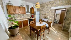 a kitchen with a table and chairs and a stone wall at La Casa Di Nonna Tella in Lenola +38 photos