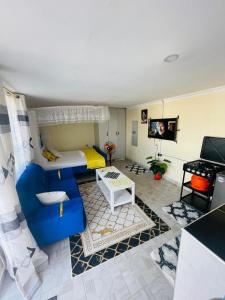 a living room with a blue couch and a tv at Tausi Studio Greenspot in Ruiru +2 photos