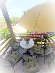 une table et des chaises avec un parasol sur un balcon dans l'établissement Apartman Petra Zabok, à Zabok