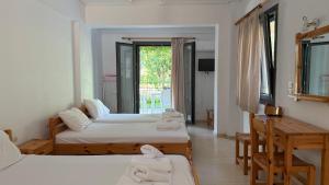 a room with two beds with towels on them at Ionian Sunset in Lefkada