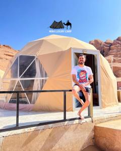 a man sitting in a tent in the desert at MIRA LUXURY CAMp in Wadi Rum