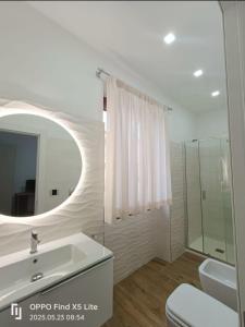a bathroom with a sink and a mirror and a toilet at Riccabea in Alghero