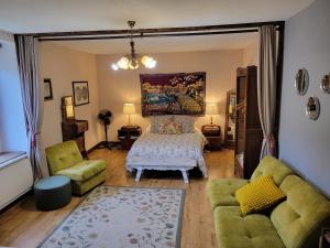 a living room with a bed and a couch at Chambre Familiale in Treignac