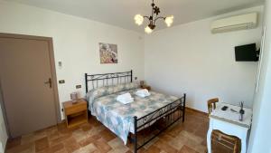 a bedroom with a bed and a table and a door at La Casa Di Nonna Tella in Lenola