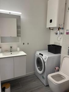 a bathroom with a washing machine and a sink at Élégant T2 acces direct plage in Saint-Cyprien-Plage