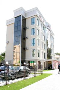 a building with a car parked in front of it at ABAI INN - Nursaya in Taraz