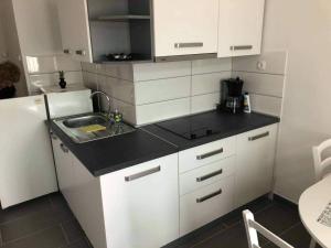 a small kitchen with white cabinets and a sink at Gajeta in Betina +8 photos