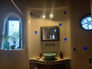 ein Badezimmer mit Waschbecken, Spiegel und Fenster in der Unterkunft Casita de Campo in Puerto Madryn