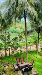 due sedie sedute sotto una palma su una spiaggia di Lake View Villa - Tangalle a Tangalle