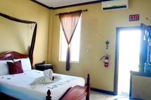 a bedroom with a bed and a window at RENOVATED See Belize TRANQUIL Sea View Studio with Balcony, Infinity Pool & Overwater Deck in Belize City