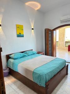 a bedroom with a large bed with blue pillows at شاليه للايجار في مارينا 5 استمتع بالزياره لا تنسى كود ج4 in El Alamein +54 photos