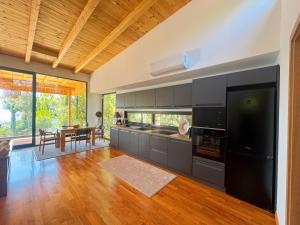 a kitchen with black cabinets and a wooden floor at Villa Ela - Cape of Rodon in Draç