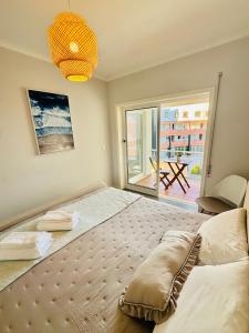 a bedroom with a large bed and a large window at Cabedelo Beach Loft in Darque