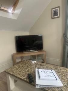 a room with a table with a book and a tv at Roe Valley Getaway in Limavady