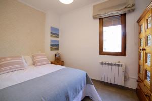 a white bedroom with a bed and a window at Apartamento Balcón al Mediterráneo in Moraira
