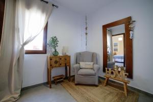 a living room with a chair and a mirror at Apartamento Balcón al Mediterráneo in Moraira