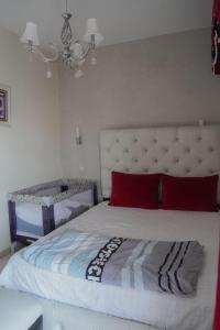 a bedroom with a large white bed with red pillows at Arina beach martil in Martil