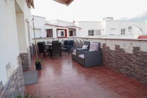 a patio with chairs and a table on a brick wall at Arina beach martil in Martil