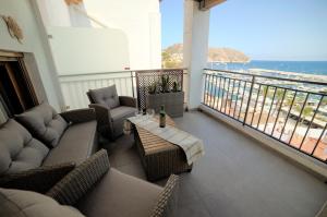 a balcony with couches and a table and a view of the ocean at Apartamento Balcón al Mediterráneo in Moraira +22 photos