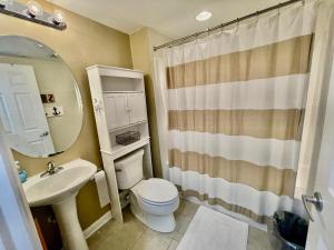 ein Badezimmer mit Toilette, Waschbecken und Spiegel in der Unterkunft Delano 3i in Rehoboth Beach + 4 Fotos