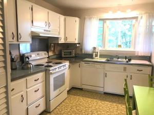 a kitchen with white cabinets and a white stove top oven at Rolling road 38 in Rehoboth Beach