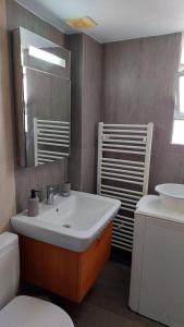 a bathroom with a sink and a toilet and a mirror at Ammophila-Lemnos 3 in Mirina