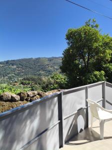 einen weißen Stuhl auf einem Balkon mit Aussicht in der Unterkunft Natura Gerês in Valdosende + 13 Fotos