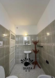 Hotel Suiza في ترماس دي ريو هوندو: حمام مع مغسلة ودورتين مياه