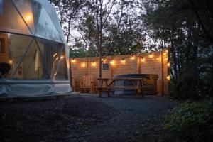 a tent with a picnic table in front of a cabin at Creekside RnR in Cocagne 