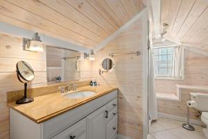 une salle de bain avec un lavabo et un miroir et des toilettes dans l'établissement Cute Beach Cottage Steps to the Beach! Panama City Beach, FL!, à Laguna Beach 48 autres photos