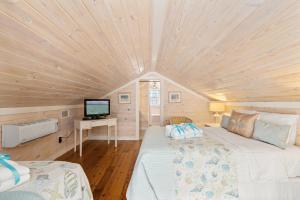 Cette petite chambre située dans une petite maison comprend un lit et une télévision. dans l'établissement Cute Beach Cottage Steps to the Beach! Panama City Beach, FL!, à Laguna Beach