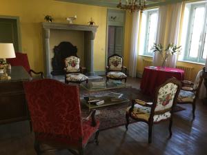 a living room with chairs and a table and a fireplace at Le Vieux Colombier in Pouzy-Mésangy +7 photos