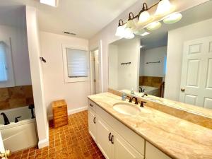 een badkamer met een wastafel en een grote spiegel bij Norfolk street 123 in Rehoboth Beach