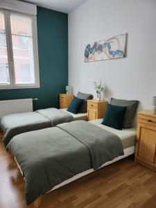 four beds in a room with blue walls at Appartement au rez-de-chaussée Nichée en plein centre d'Arras in Arras +12 photos