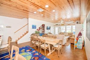 a dining room with a table and chairs and a staircase at Eleventh Street in Mustang Beach