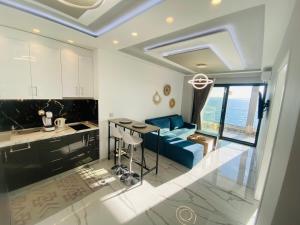 a kitchen and living room with a blue couch at Candi Luxury Suites in Neos Marmaras