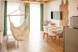 a room with a hammock and a table and chairs at Chillera Domki in Łeba +79 photos