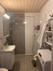 a bathroom with a shower and a washing machine at Huhtiniemenranta in Lappeenranta