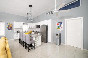 a kitchen with white cabinets and a table with chairs at Luxury Villa, Garden View and Private Pool in La Mulata
