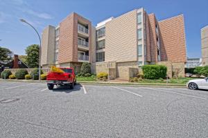 a red truck parked in a parking lot in front of a building at The crest 304 in Rehoboth Beach +2 photos
