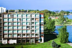a building next to a body of water at Hotel Hungária in Siófok