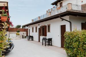 a white house with black chairs and a balcony at Bed & Breakfast Memory in Castelbasso