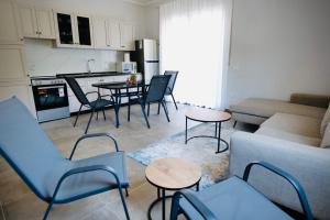 a living room with a couch and a table and chairs at Aren Suite in Vlorë