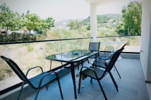 a glass table with chairs and a laptop on a balcony at Aren Suite in Vlorë